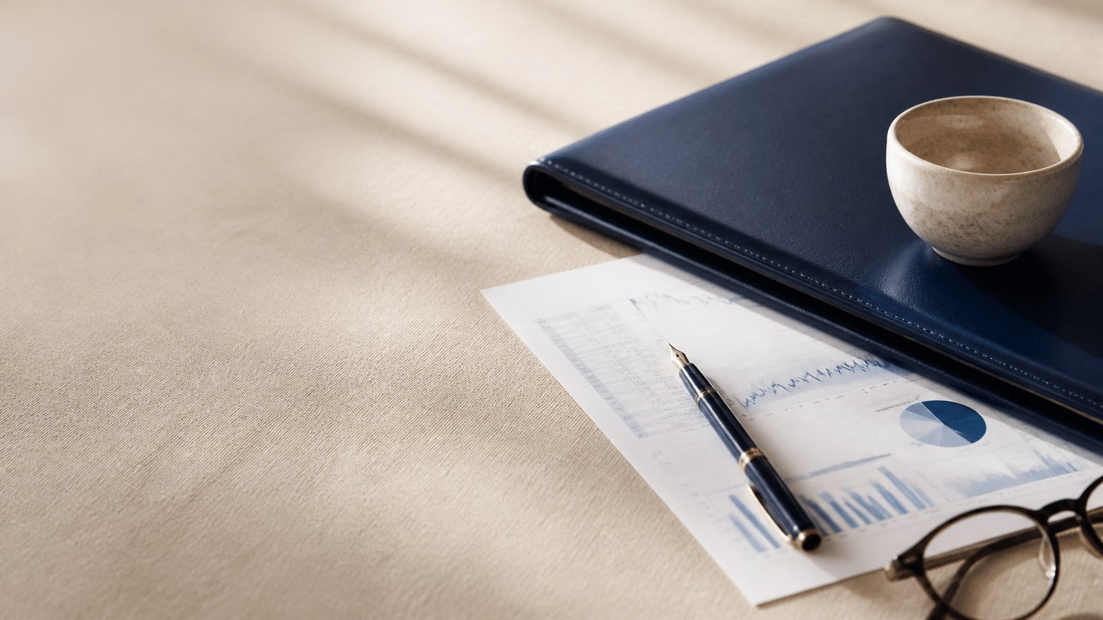 Relevé de compte-titres, stylo et portefeuille bleu marine sur un bureau : préparer des revenus de retraite avec un compte-titres